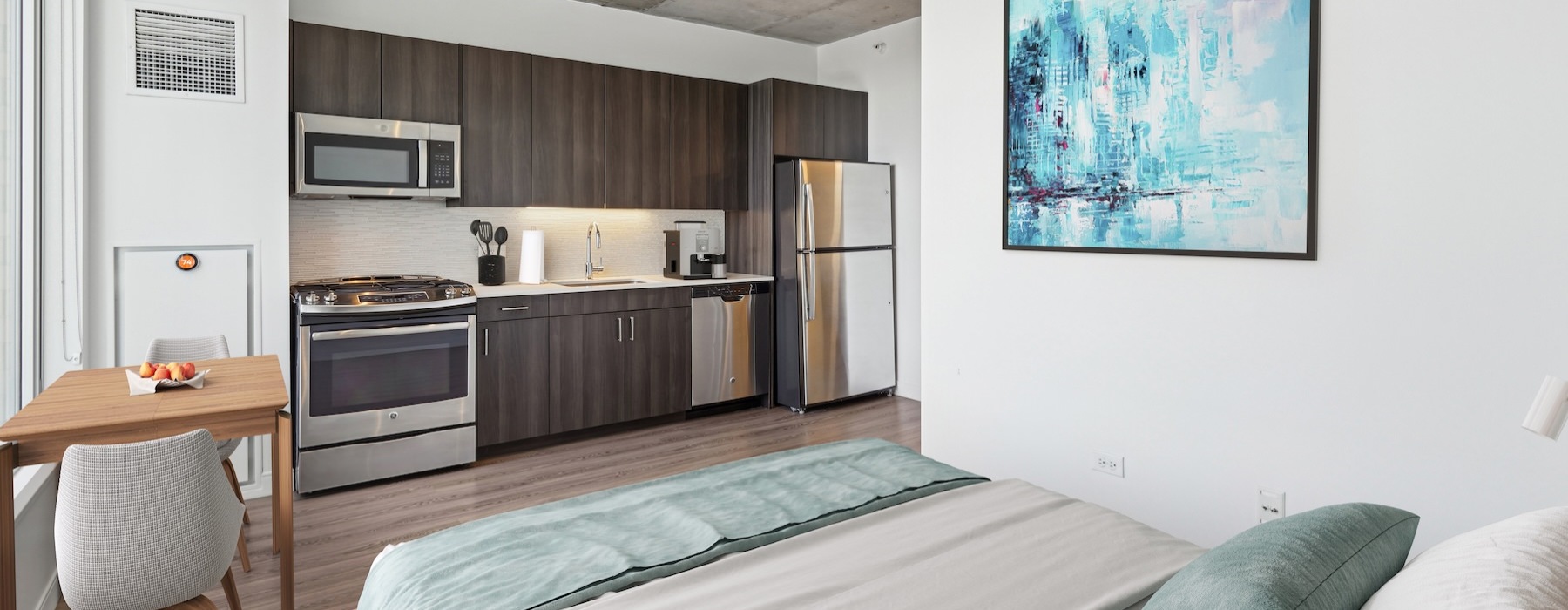 a studio with a bed and a kitchen